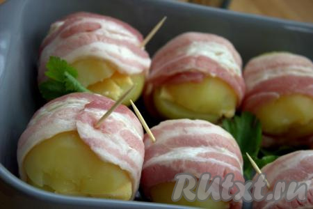 Затем в форму для запекания в один слой выложить картофель в беконе. Для того чтобы бекон не разворачивался, можно для надёжности скрепить картошку в беконе зубочистками.&nbsp;