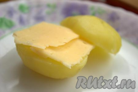 Разрезать каждую картофелину вдоль на две части. Поверх одной половинки картошки положить ломтик сыра, накрыть второй половинкой картошины, слегка посолить и приправить специями по вкусу.