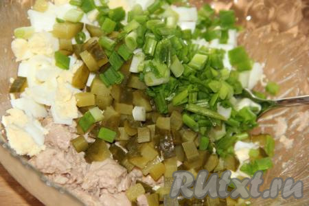 К печени трески выложить нарезанные яйца, огурцы и зелёный лук.