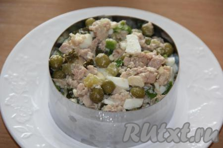 В салат из яиц, печени трески, зелёного лука и солёных огурцов добавить горошек, соль по вкусу и майонез, перемешать. Подать этот салат можно порционно или в одном салатники. Я выложила его в форму для формирования салата, слегка утрамбовала.