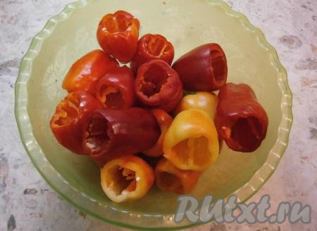 У каждого перца отрезать верхушку с хвостиком и аккуратно, чтобы не повредить перчик, удалить семенную коробку.