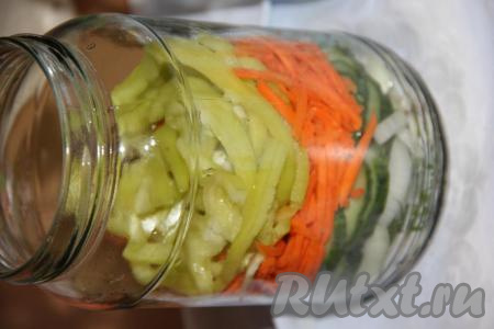 Морковь натереть на тёрке для моркови по-корейски. Удалить из болгарского перца семена, а затем нарезать длинными полосками. Выложить в банки слой моркови, а сверху разложить полоски перца.