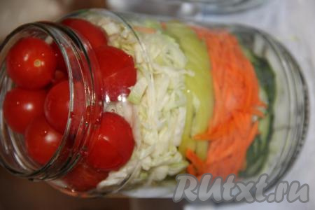 Белокочанную капусту нарезать длинными полосками. Помидоры черри вымыть. Выложить в каждую банку слой капусты, а сверху уложить помидоры.
