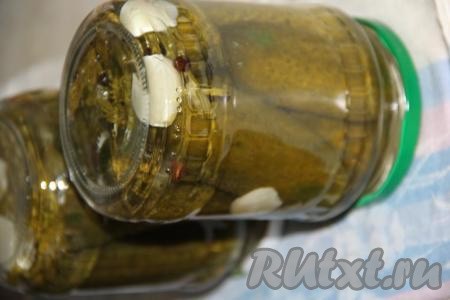 Аккуратно достать банки из горячей воды, закрутить крышки. Перевернуть баночки с огурчиками вверх дном, укутать в одеяло и оставить до полного остывания.&nbsp;После того как банки полностью остынут, их можно убирать на хранение.