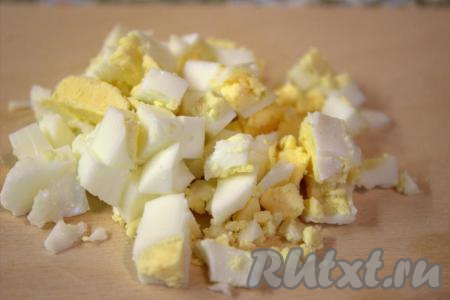 Куриные яйца отварить вкрутую (время варки составит 10 минут с момента закипания воды), затем охладить в холодной воде, очистить и нарезать средними кубиками.