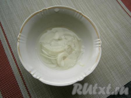 Лук очистить, нарезать тонкими полукольцами и залить крутым кипятком на 1 минуту, затем воду слить, а лучок отжать.