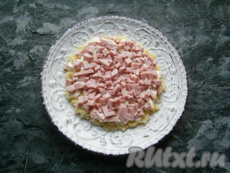 Следующим слоем выложить нарезанную небольшими кубиками ветчину + немного майонеза.