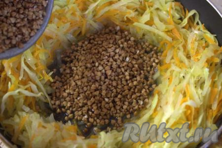 Затем в сковороде отодвинуть в сторону капусту и морковку так, чтобы в середине образовалось углубление. В это углубление выложить гречневую крупу.