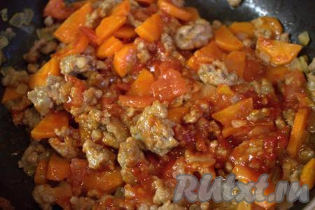 Затем добавить томатную пасту, посолить, приправить специями по вкусу, хорошо перемешать, сковороду накрыть крышкой и тушить фарш с овощами на небольшом огне 5 минут, помешивая время от времени.