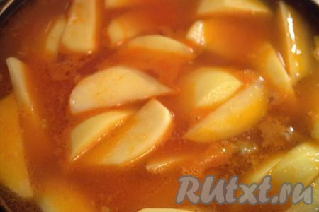 Тем временем картошку очистить, нарезать дольками среднего размера, затем выложить в сковороду к овощам и фаршу. Влить воду (или мясной бульон) так, чтобы вода полностью покрывала картофель. Воды может понадобиться чуть больше или меньше стакана. Добавить лавровый лист, по желанию, можно ещё приправить по вкусу. Сковороду накрыть крышкой и тушить картошку с фаршем на медленном огне, примерно, 20-25 минут (картофель должен стать достаточно мягким, но при этом не развариться).