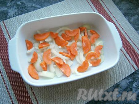 На дно подходящей формы для запекания выложить нарезанный полукольцами репчатый лук и нарезанную полукружочками морковь, полить растительным маслом.