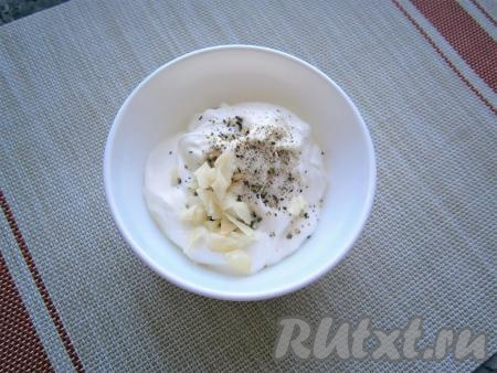 В сметану добавить немного соли, свежемолотый перец и нарезанный кусочками чеснок, перемешать.