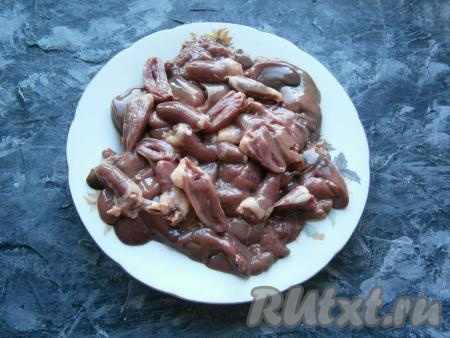 Куриную печень и сердечки вымыть, печёнку разрезать на несколько частей, сердечки - на 2 части, а затем тщательно промыть.
