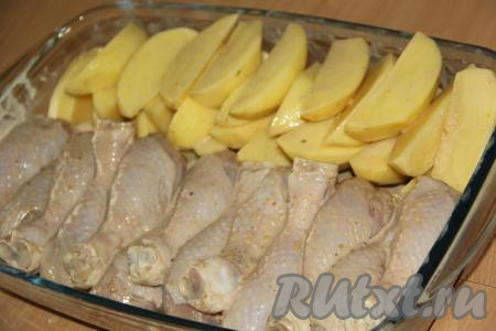 Затем выложить в жаропрочную форму с одной стороны куриные ножки, с другой стороны - дольки картофеля.