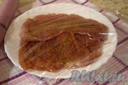 Посолить каждый отбитый кусочек мяса, приправить по вкусу. Сложить куски свинины в тарелку, накрыть пищевой плёнкой и отставить в сторону на 20-30 минут.