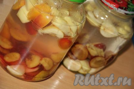 Разложить фруктовое ассорти по простерилизованным банкам. В кастрюле вскипятить воду и залить фрукты в банках кипящей водой. Я вскипятила 4 литра воды. Воды должно быть столько, чтобы банки заполнялись практически до верха. Банки с фруктовым ассорти, прикрыв прокипячёнными крышками, оставить на 20 минут.