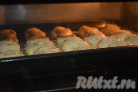 Даём дрожжевым булочкам с вареньем подойти, примерно, 20 минут при комнатной температуре. Далее противень с булочками отправляем в разогретую духовку и выпекаем при температуре 180 градусов, примерно, 30 минут.