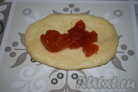 Далее каждый кусочек теста округляем, раскатываем скалкой в овал и выкладываем варенье на середину овала.