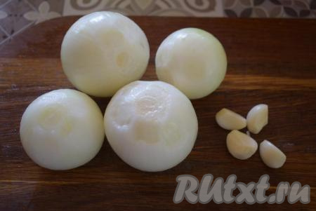 Отделить мякоть говядины от кости и нарезать на кусочки среднего размера, помещающиеся в мясорубку. Лук и чеснок очистить, лук нарезать на части.