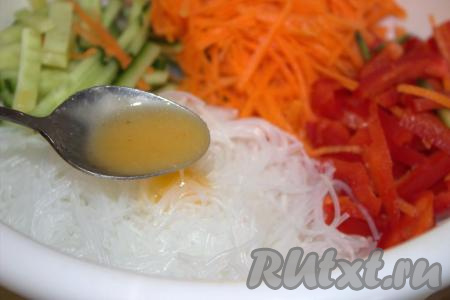 В глубокой миске соединить фунчозу, натёртую морковь, нарезанные огурцы и болгарский перец, добавить приготовленную заправку, хорошо перемешать салат.