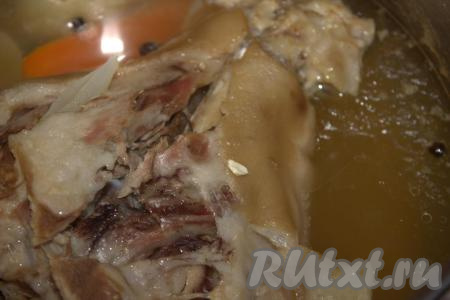 Довести воду до кипения, снять пену, убавить огонь до минимума. Добавить в кастрюлю очищенную морковь и очищенный лук, лавровый лист, горошины душистого и чёрного перцев. Кастрюлю прикрыть крышкой и варить свиную рульку на медленном огне до отделения мяса от кости (примерно, 5-6 часов).