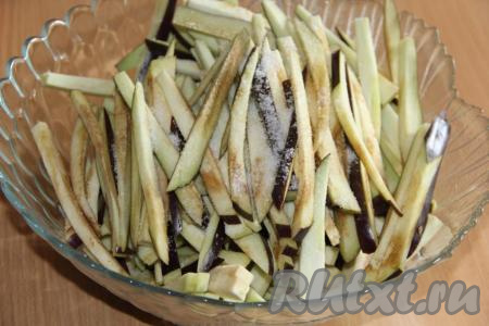 Баклажаны вымыть, нарезать длинными и тонкими брусочками. К нарезанным баклажанам всыпать 1 столовую ложку соли.