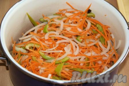 Выложить в глубокую кастрюлю баклажаны вместе с маслом, на котором они обжаривались, добавить морковь, болгарский перец и лук.