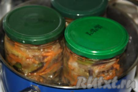 В большую кастрюлю налить холодную воду. Для того чтобы банки не лопнули в процессе стерилизации, дно кастрюли можно застелить тряпочкой, сложенной в несколько раз. Поместить банки с овощной смесью в кастрюлю (вода должна доходить до "плечиков" банок), поставить на средний огонь. С момента закипания воды в кастрюле стерилизовать банки с овощами 20 минут.