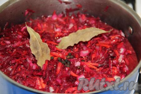 Перемешать овощи, добавить лавровые листочки и горошины чёрного перца. Поставить кастрюлю на средний огонь. Довести свекольную икру до кипения, затем накрыть кастрюлю крышкой и варить на среднем огне 1 час, перемешивая время от времени.