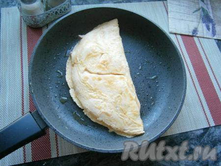 Накрыть начинку с помощью лопатки второй частью омлета (сложить, как чебурек).