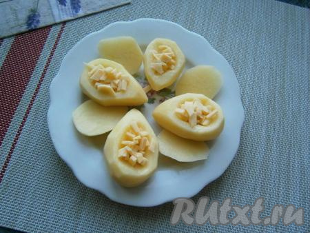 Твёрдый сыр нарезать маленькими кубиками и наполнить им углубления в картофеле.