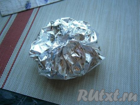 Завернуть картофель в фольгу, не переворачивая его (то есть "крышечка" должна быть вверху и после заворачивания картошки в фольгу).