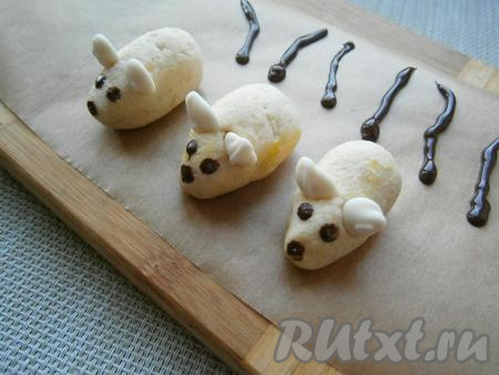 Из оставленной белой массы крема и печенья вылепить мышек, вставить ушки из капель белого шоколада. Тёмный шоколад растопить, немного остудить и перелить в кондитерский мешок, срезать кончик. Сделать шоколадом глазки и носики, отсадить на пергамент полосочки в виде хвостиков (сделайте их больше, на случай, если какой-то хвостик поломается).&nbsp;Мышек и хвостики поместить в холодильник минут на 15 для застывания.