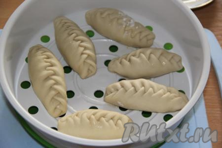 В мультиварку влить воду и выставить режим "На&nbsp;пару". Смазать поддон для пароварки растительным маслом и выложить манты не плотно друг к другу.