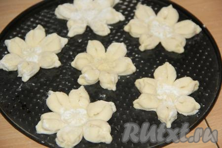 Противень смазать растительным маслом и выложить на него заготовки булочек-цветочков.