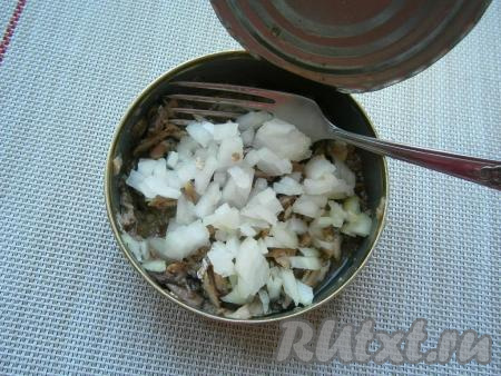 В банку к размятым шпротам выложить очищенный и мелко нарезанный репчатый лук, перемешать его с рыбкой.