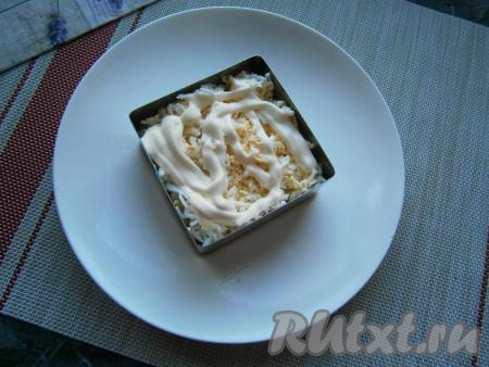 Далее равномерно выложить натёртые варёные яйца, немного их посолить, смазать майонезом.