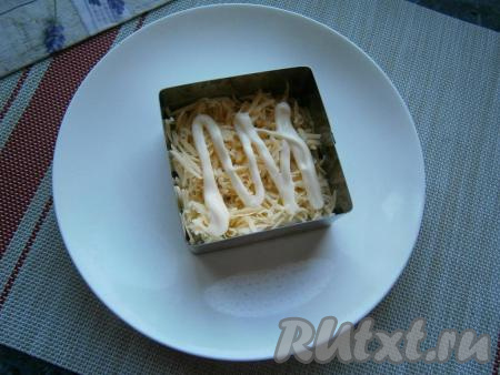 Следующим слоем выложить натёртый на мелкой тёрке сыр, нанести майонез.