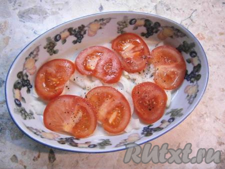 В подходящую по размеру форму для запекания выложить вторую очищенную луковицу, нарезанную кольцами (или полукольцами), сверху разложить кружочки свежих помидоров, чуть посолить и поперчить.