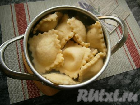 Влить в кастрюлю воду, отправить на огонь и довести до кипения, посолить. В закипевшую воду выложить равиоли, снова дать воде закипеть. Затем уменьшить огонь и варить равиоли в течение 5-7 минут (до готовности).