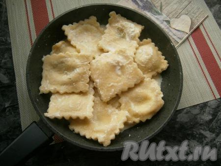 Шумовкой достать равиоли из воды и выложить в соус, перемешать. Прогревать их на слабом огне под закрытой крышкой около 2-3 минут.