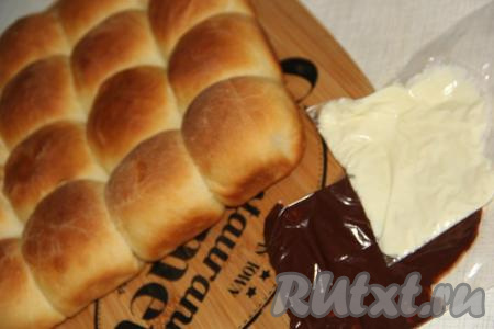 Пирог слегка остудить и переложить на разделочную доску. Теперь можем украсить наш пирог из булочек тёмным и белым шоколадом.&nbsp;Шоколад растопить на водяной бане.