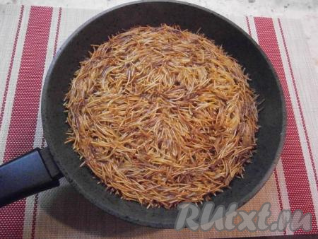 Когда вермишель станет коричневого цвета, влить очень горячую воду, смешанную с солью, накрыть сковороду крышкой, огонь уменьшить до минимального.