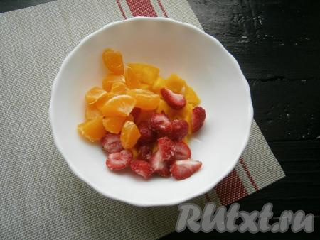 Половину нарезанного манго отложить в сторону (мы её будем использовать для приготовления заправки для фруктового салата). Вторую половину нарезанного манго поместить в миску, добавить 5-6 ягод клубники, разрезанных на 2-4 части, и разрезанные на 2 части дольки мандарина.