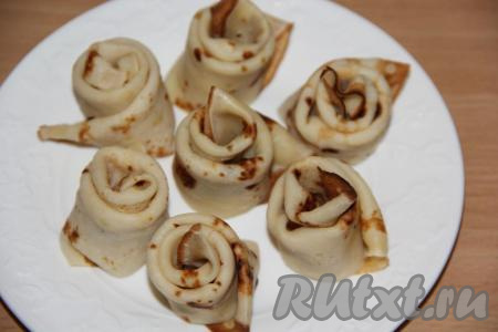 Получившуюся полоску свернуть рулетиком в виде розочки, край блина завернуть вниз. Выложить блинные розочки на&nbsp;тарелку.