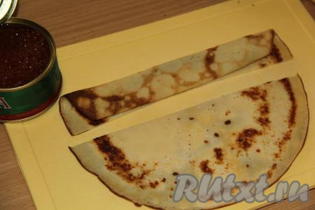 Готовые блинчики можно с пылу с жару подать к столу. Я же решила их красиво оформить, свернув в виде розочек, и подать с красной икрой. Для того чтобы свернуть блинчики в виде розочек, нужно блины нарезать на полоски шириной, примерно, 5&nbsp;см. Свернуть каждую полоску пополам в длину.