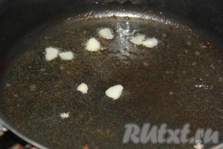 Обжаренную курицу переложить со сковороды на тарелку. А на сковороду с маслом выложить очищенный и нарезанный на пластины чеснок, обжарить 1 минуту на среднем огне.