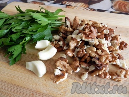 Петрушку (или кинзу) вымыть, обсушить, нарезать. Зубчики чеснока очистить, нарезать.