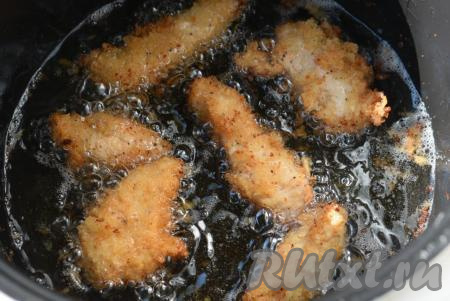 Выкладываем куриное филе небольшими партиями в разогретое масло и жарим до золотистой румяной корочки, периодически переворачивая со стороны на сторону (в мультиварке на режиме "Выпечка" на приготовление филе потребуется, примерно, 12-15 минут, а при жарке на сковороде на среднем огне достаточно будет 8-10 минут).