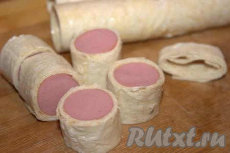 Острым ножом разрезать получившиеся рулетики на небольшие кусочки одинакового размера (размер каждого отрезанного кусочка должен быть, примерно, 2-3 сантиметра).